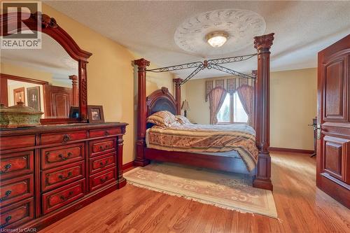 Hardwood flooring, decorative ceiling medallion with a flush-mount light fixture, and a paneled interior door - 23 Susan Drive, Hamilton, ON 