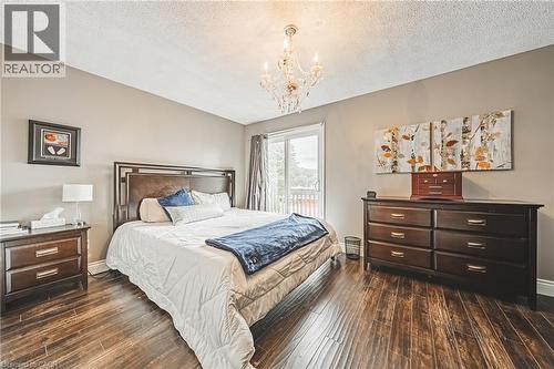 Wood-finish flooring, sliding glass door, overhead chandelier, and neutral wall paint - 266 Limeridge Road E Unit# 3, Hamilton, ON 