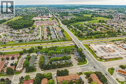 Aerial perspective showcasing an expansive residential area, verdant green spaces, multiple roadways, and an overpass - 266 Limeridge Road E Unit# 3, Hamilton, ON 