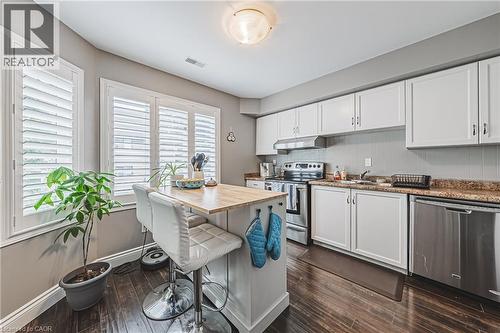 Kitchen featuring white cabinetry, stainless steel appliances, wood-finish flooring, and a central island with a wood countertop - 266 Limeridge Road E Unit# 3, Hamilton, ON 