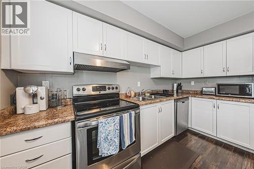 White cabinetry with chrome hardware, stainless steel appliances, wood-finish flooring, and a stone-look countertop - 266 Limeridge Road E Unit# 3, Hamilton, ON 