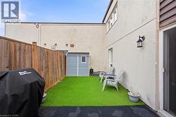 Enclosed patio featuring artificial turf, privacy fencing, and a built-in outdoor lantern - 