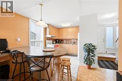 Kitchen featuring wood-finish cabinetry, white appliances, and a breakfast bar with an integrated desk area - 