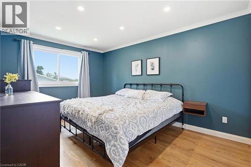 Bright room featuring wood-finish flooring, recessed lighting, and a wide window with white trim - 72 Crestlynn Crescent, Simcoe, ON 