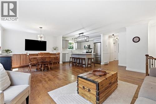 Open-concept living space featuring wood-finish flooring, white walls, and crown molding - 72 Crestlynn Crescent, Simcoe, ON 