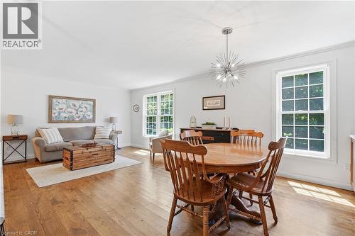 Open-concept living space featuring wood-finish flooring, white walls, and bright natural light from multiple windows - 72 Crestlynn Crescent, Simcoe, ON 
