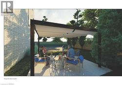 The property features an outdoor patio area with a pergola, a paved surface, and a grassy lawn - 