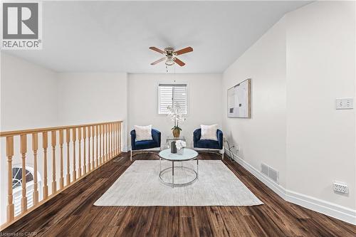 Wood-finish flooring, light-toned wall paint, wood railing, window with blinds, and a ceiling fan - 495 Brigantine Drive, Waterloo, ON 