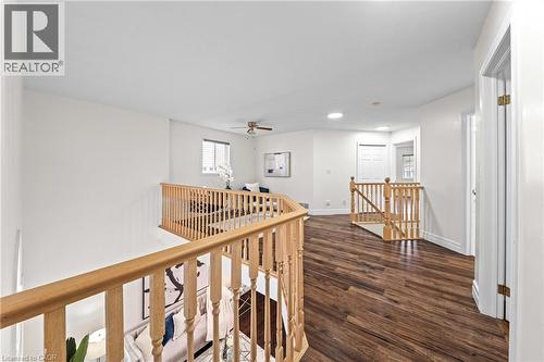 Open-concept upper level featuring wood-finish flooring, recessed lighting, and natural wood railings - 495 Brigantine Drive, Waterloo, ON 