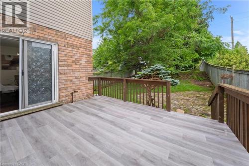 Outdoor deck with wood-finish flooring, wood railing, and brick exterior - 495 Brigantine Drive, Waterloo, ON 