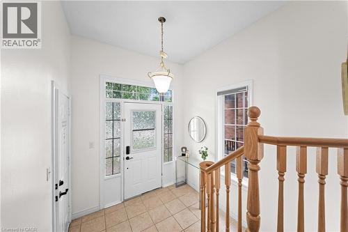 Entryway featuring a white paneled door with glass inserts, transom window, and tiled flooring - 495 Brigantine Drive, Waterloo, ON 