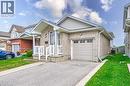 Light brick exterior with white siding accents, covered front entry with columns and railings, attached garage with panel door and window inserts, paved driveway, and established lawn - 168 Copper Leaf Street, Kitchener, ON 
