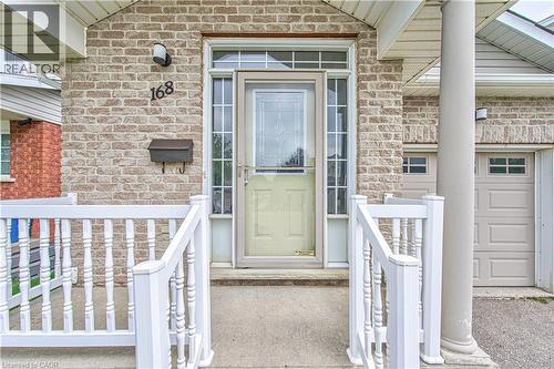 Brick exterior with a covered porch, white railing, and a side-light front entry door - 168 Copper Leaf Street, Kitchener, ON 