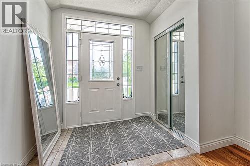 Entryway with a paneled door featuring decorative glass, sidelight windows, and a transom window - 168 Copper Leaf Street, Kitchener, ON 