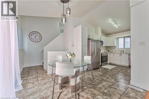 Kitchen featuring white cabinetry, stainless steel appliances, and a tile backsplash - 168 Copper Leaf Street, Kitchener, ON 