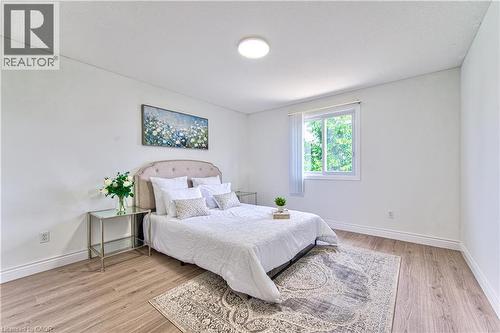 Wood-finish flooring, white walls, white trim, and a white-framed window - 168 Copper Leaf Street, Kitchener, ON 