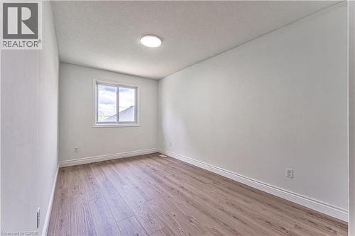 Recessed ceiling lighting, wood-finish flooring, and a single window with white trim - 168 Copper Leaf Street, Kitchener, ON 
