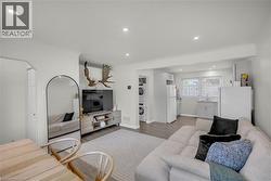 Bright living area featuring wood-finish flooring and recessed lighting - 