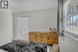 Bedroom Neutral wall color, wood-finish flooring, and white bi-fold closet doors - 