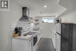 Compact kitchen featuring white cabinetry, light countertops, and a white subway tile backsplash - 