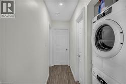 Dedicated laundry area featuring a stacked washer and dryer unit - 