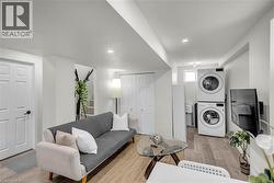 Open-concept living area featuring light wood-finish flooring, recessed lighting, and a neutral white color palette - 