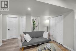 Living area featuring wood-finish flooring, recessed lighting, white paneled doors, and bi-fold closet doors - 