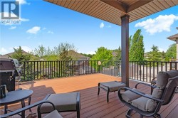 Covered outdoor deck with composite decking, black metal railings, and a solid support column - 