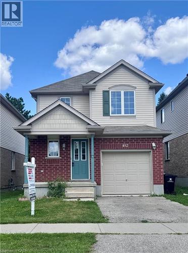 Two-story residence featuring brick and siding facade with a covered front porch and a teal entry door - 452 Beaumont Crescent, Kitchener, ON 