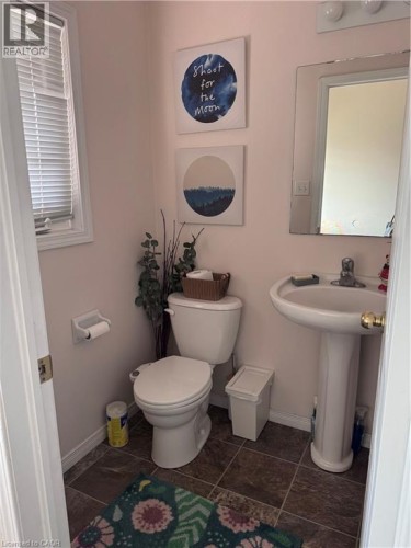 Bathroom featuring a pedestal sink, wall-mounted mirror, and tile flooring - 452 Beaumont Crescent, Kitchener, ON 