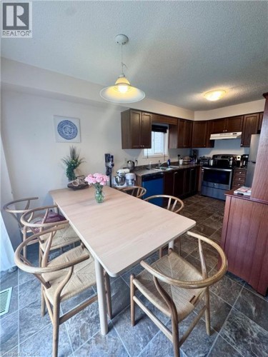 Dining area with tile flooring and a light wood-finish table - 452 Beaumont Crescent, Kitchener, ON 