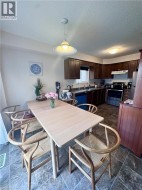 Dining area with tile flooring and a light wood-finish table - 