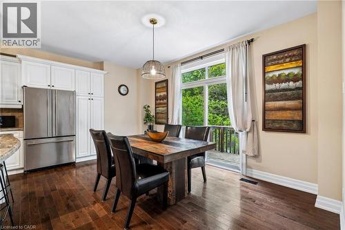 Spacious dining area featuring wood-finish flooring, white cabinetry, and stainless steel appliances - 1541 Garnet Avenue, Mississauga, ON 