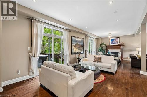 Living room featuring wood-finish flooring, recessed lighting, and a glass-paneled patio door leading to an outdoor deck - 1541 Garnet Avenue, Mississauga, ON 