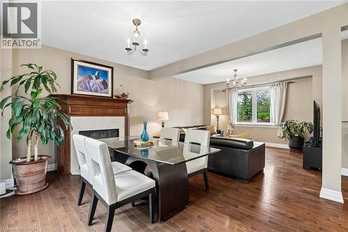 Open concept living area featuring wood-finish flooring, a fireplace with a wood mantle, and a large window - 1541 Garnet Avenue, Mississauga, ON 