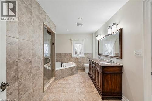 Expansive bathroom featuring a glass-enclosed shower, corner soaking tub, and a dual-sink vanity with a wood-finish cabinet - 1541 Garnet Avenue, Mississauga, ON 