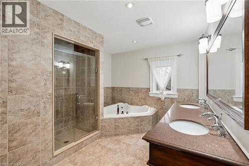 Tiled bathroom featuring a glass-enclosed shower, corner soaking tub, and a double vanity with integrated sinks - 1541 Garnet Avenue, Mississauga, ON 