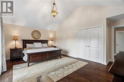 Vaulted ceiling featuring a decorative pendant light fixture, dark wood-finish flooring, and white bifold doors - 1541 Garnet Avenue, Mississauga, ON 