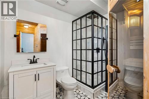 Bathroom featuring a white vanity with an integrated sink, matte black faucet, and a black-grid glass shower enclosure - 1541 Garnet Avenue, Mississauga, ON 