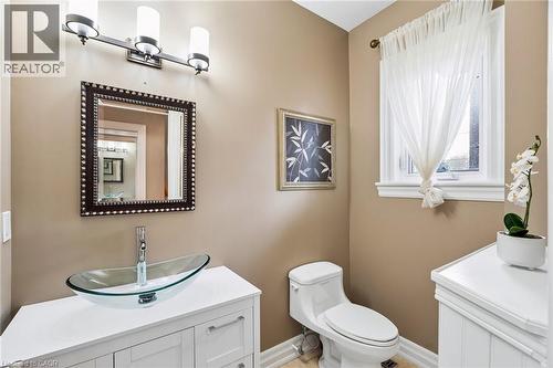 Bathroom featuring a white vanity with a glass vessel sink, chrome faucet, and a decorative framed mirror - 1541 Garnet Avenue, Mississauga, ON 