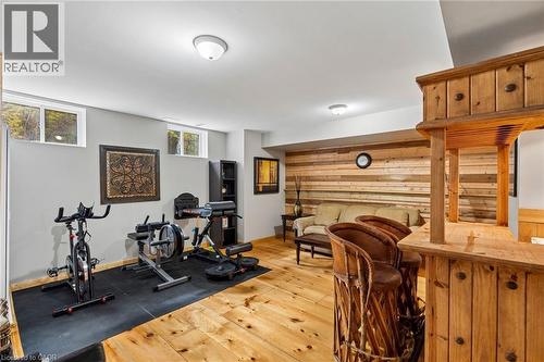Finished lower level featuring a built-in wood bar, wood-plank accent wall, wood-finish flooring, and recessed lighting - 1541 Garnet Avenue, Mississauga, ON 