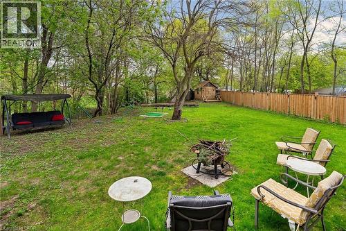 Expansive backyard featuring a manicured lawn, mature trees, and a privacy fence - 1541 Garnet Avenue, Mississauga, ON 