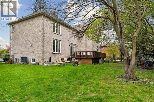 Expansive green lawn with mature trees and a multi-level wooden deck - 1541 Garnet Avenue, Mississauga, ON 