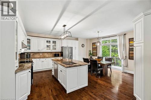Kitchen featuring an expansive island with a double basin sink, stone countertops, and stainless steel appliances - 1541 Garnet Avenue, Mississauga, ON 