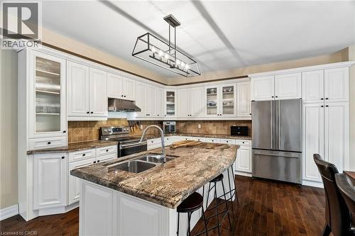 Bright kitchen featuring a substantial island with seating, a dual basin stainless steel sink, and a high-arc faucet - 1541 Garnet Avenue, Mississauga, ON 