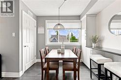 Dining area with a large window, dark wood-finish flooring, recessed lighting, and built-in cabinetry with a dark countertop - 