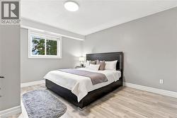 Recessed window with white trim, light gray painted walls, wood-finish flooring, and a flush mount ceiling light fixture - 