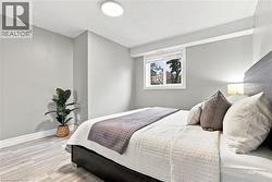 Neutral wall color, light wood-finish flooring, recessed lighting, and a white framed window - 