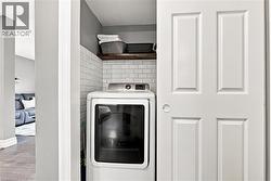 Laundry area featuring subway tile backsplash, a wood-finish shelf, and a four-panel interior door - 
