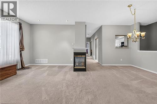 Open concept living / dining room with 3 way fireplace and pot lighting. - 159 Thoroughbred Boulevard, Ancaster, ON 